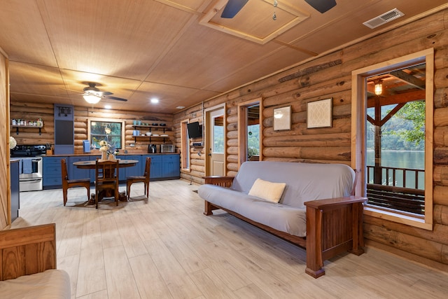 living room featuring light wood-type flooring, rustic walls, and wooden ceiling