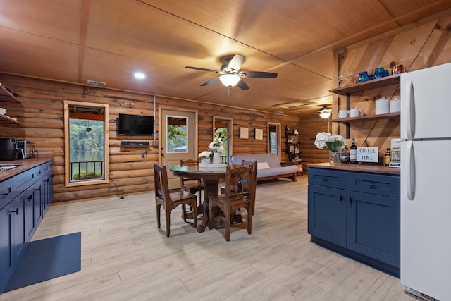 dining area with ceiling fan, light hardwood / wood-style floors, wood ceiling, and rustic walls