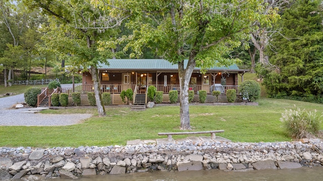 view of front facade featuring a front yard, a porch, and a water view