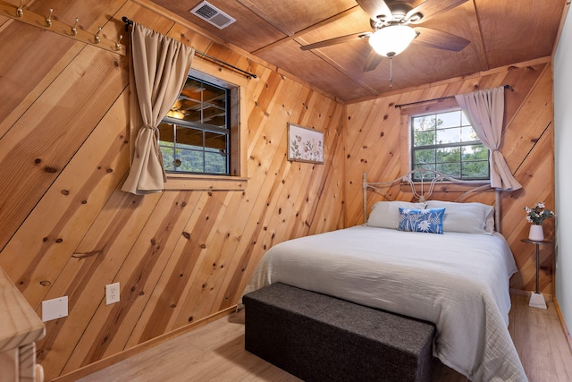 bedroom featuring wood walls, wood ceiling, and hardwood / wood-style flooring