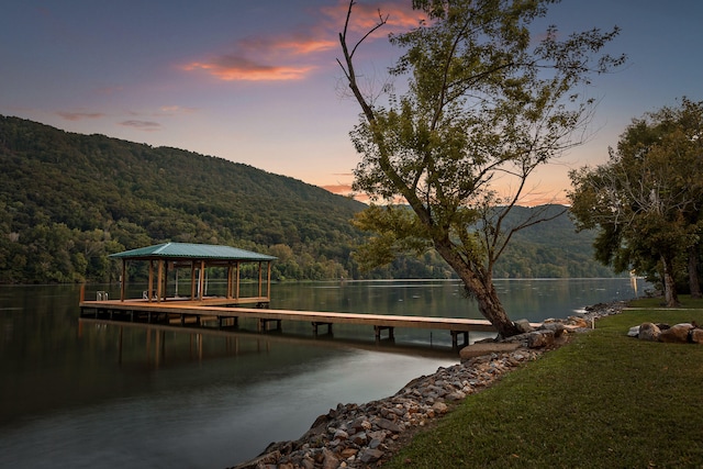 dock area featuring a water and mountain view and a lawn