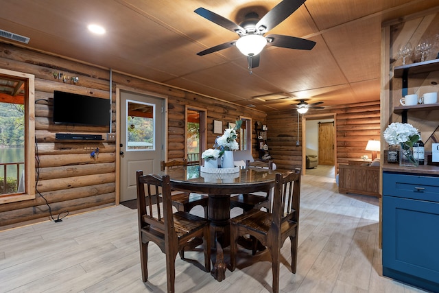 dining space with log walls, wood ceiling, and light wood-type flooring