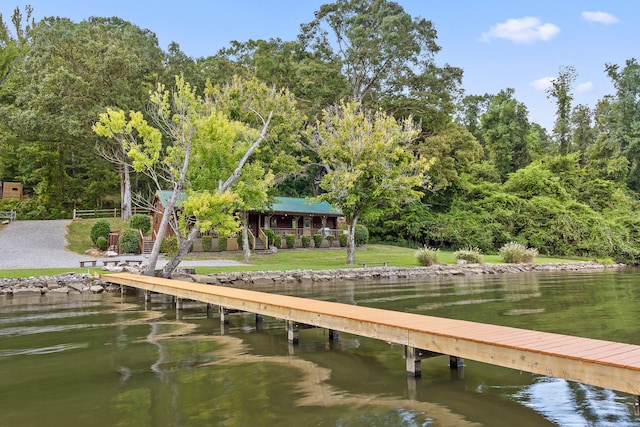 view of dock featuring a yard and a water view