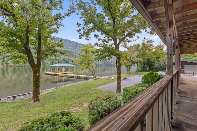 view of yard with a dock and a water and mountain view