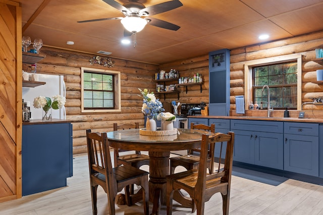 dining area with log walls and light hardwood / wood-style floors