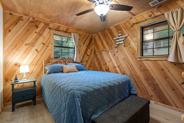 bedroom with wood walls, light hardwood / wood-style flooring, ceiling fan, and wood ceiling