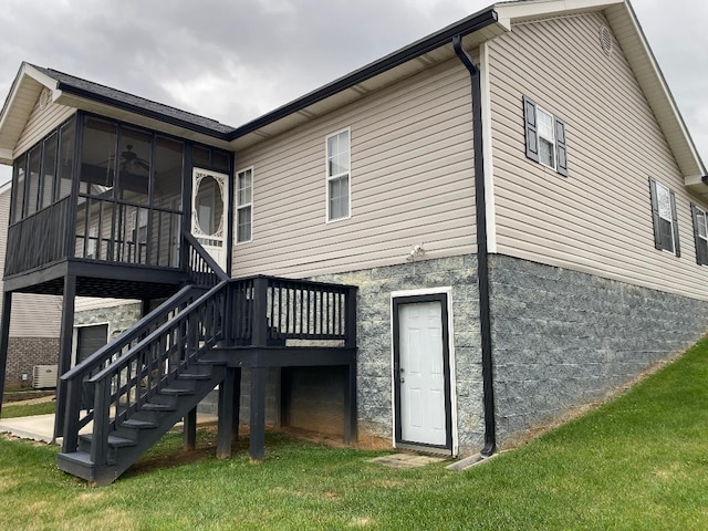 back of house featuring a lawn and a sunroom