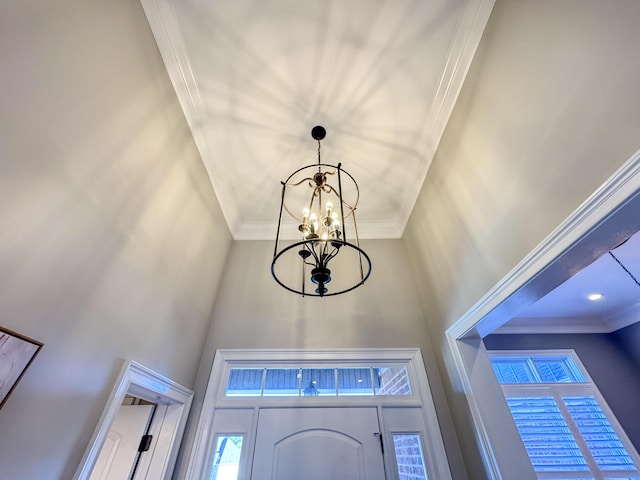 details featuring ornamental molding and an inviting chandelier