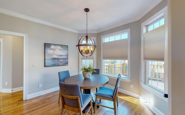 dining space with plenty of natural light, crown molding, a chandelier, and light wood-type flooring