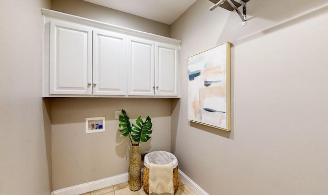 clothes washing area featuring cabinets, washer hookup, and light tile patterned flooring