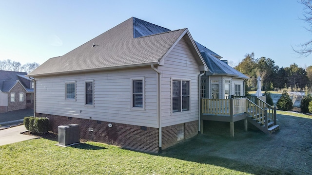 view of side of property with a lawn and cooling unit