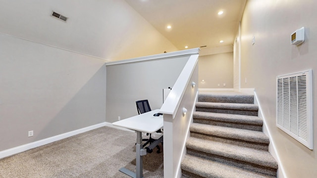 stairway with carpet floors and high vaulted ceiling