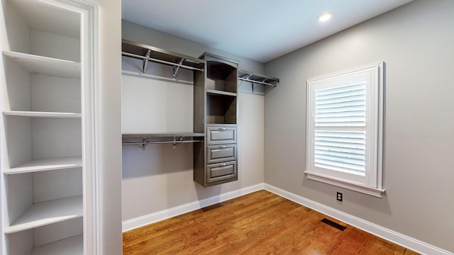 walk in closet with hardwood / wood-style flooring