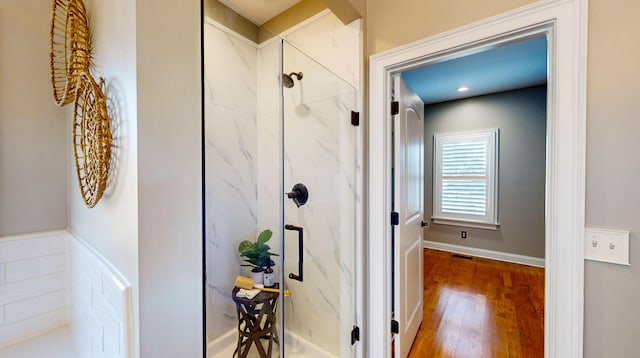 bathroom with an enclosed shower and hardwood / wood-style flooring