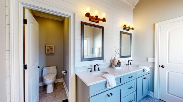 bathroom featuring hardwood / wood-style floors, toilet, vanity, and crown molding