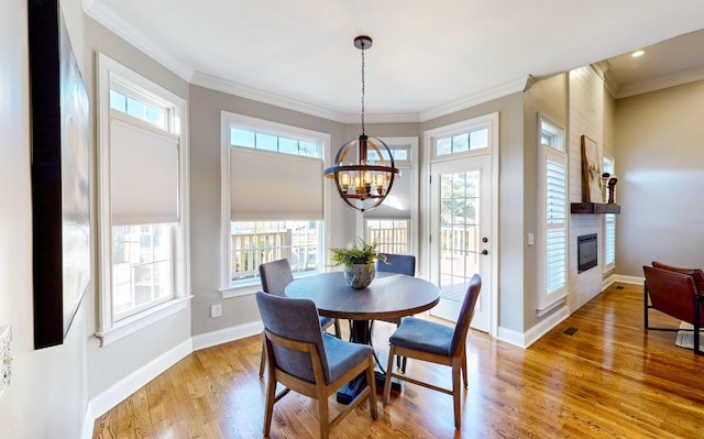 dining area with a fireplace, plenty of natural light, and a notable chandelier