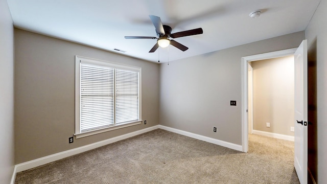 carpeted spare room featuring ceiling fan