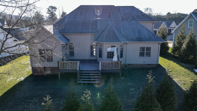 rear view of house with a deck and a lawn