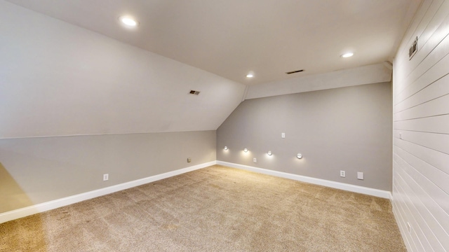 additional living space featuring carpet flooring and lofted ceiling