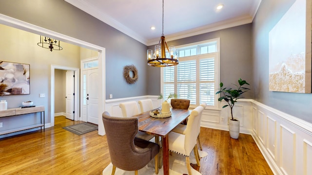 dining room with ornamental molding, a chandelier, and light hardwood / wood-style flooring