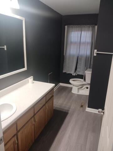 bathroom with toilet, vanity, and hardwood / wood-style flooring