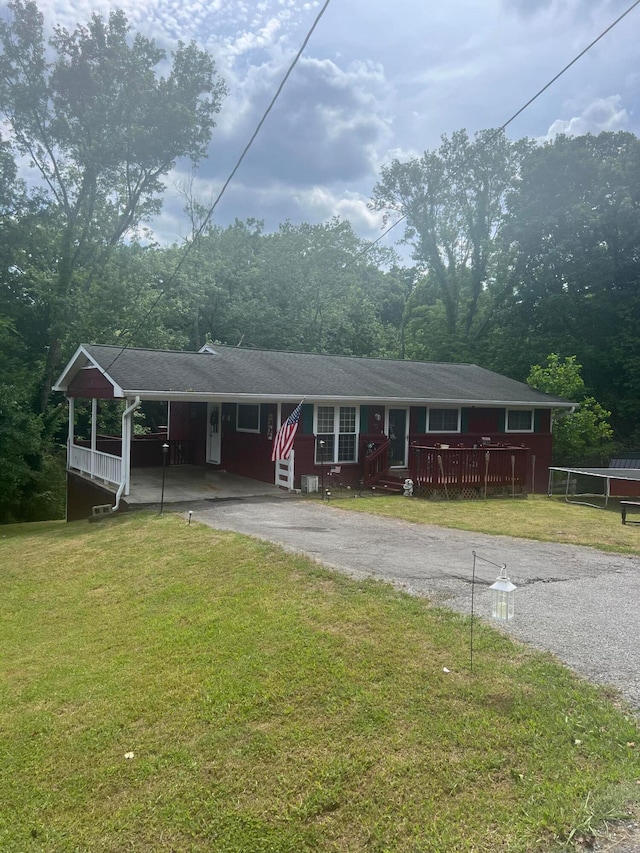 view of front of property featuring a front lawn, a carport, and a wooden deck