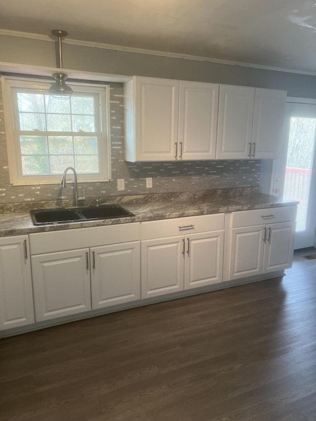 kitchen featuring white cabinetry, dark wood-type flooring, crown molding, and a sink
