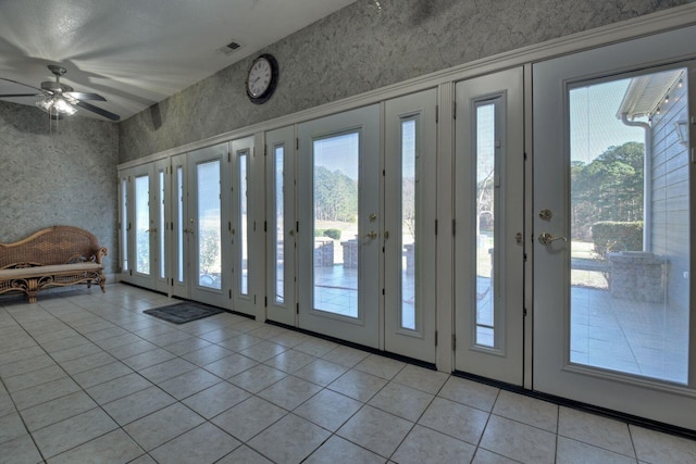 entryway featuring ceiling fan, light tile patterned floors, and a healthy amount of sunlight