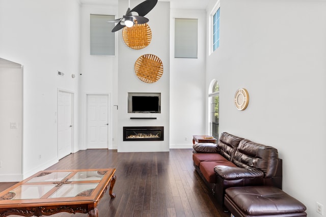 6706 Willow Trace Dr, Chattanooga, TN 37421 - living area featuring a towering ceiling, a ceiling fan, wood-type flooring, a glass covered fireplace, and baseboards
