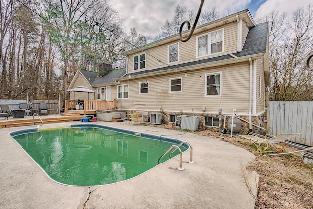 view of pool with a deck, fence, a hot tub, and a gazebo