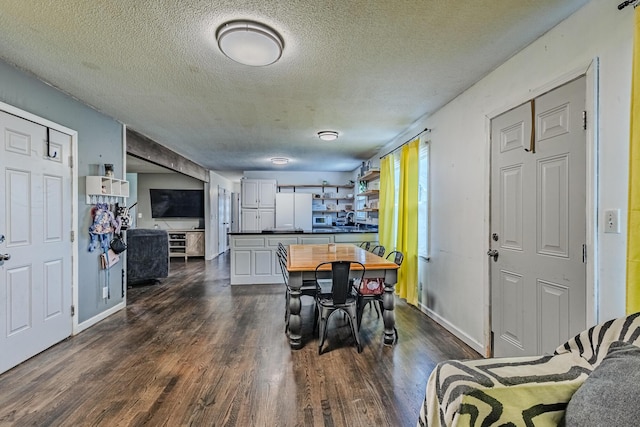 dining room featuring dark wood-type flooring, a textured ceiling, and baseboards