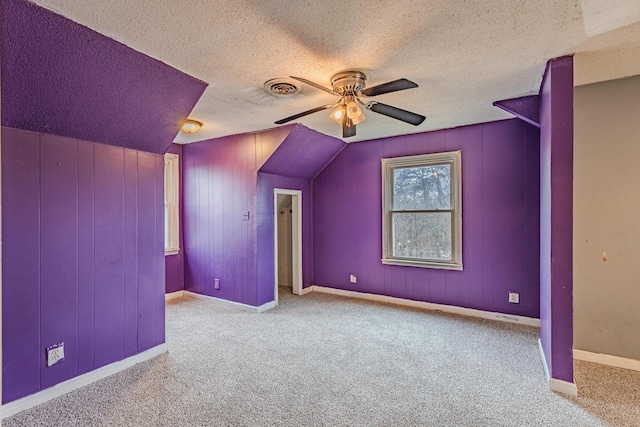 additional living space featuring ceiling fan, a textured ceiling, carpet, and visible vents