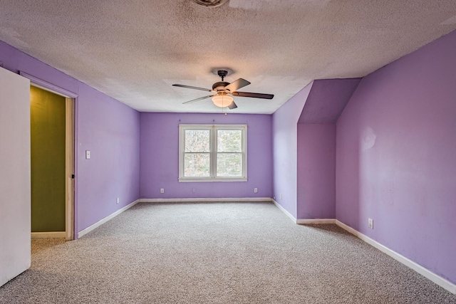 interior space with ceiling fan, a textured ceiling, carpet flooring, and baseboards