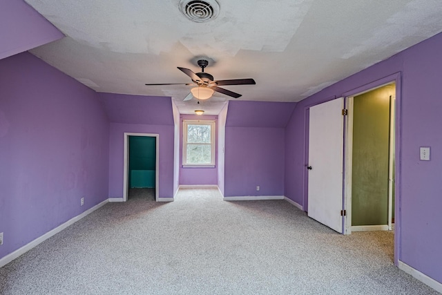 additional living space featuring lofted ceiling, visible vents, light carpet, and baseboards