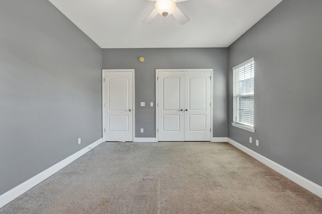 unfurnished bedroom with ceiling fan and light colored carpet