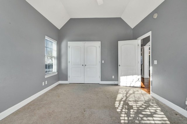 unfurnished bedroom featuring carpet floors, a closet, and lofted ceiling