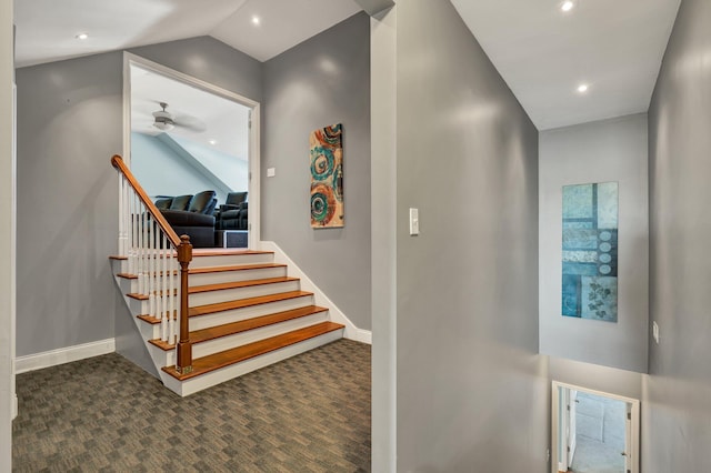 stairs with ceiling fan, carpet, and vaulted ceiling