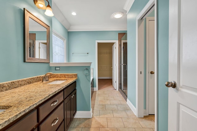 bathroom with tile patterned flooring, vanity, a shower with door, and ornamental molding