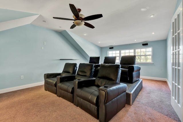 carpeted cinema room with ceiling fan and vaulted ceiling