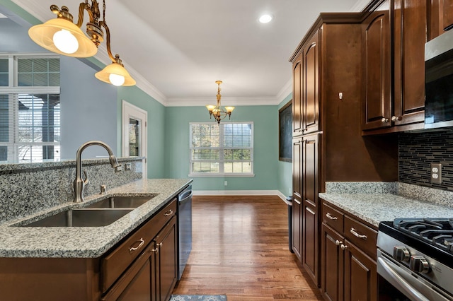 kitchen with appliances with stainless steel finishes, light stone counters, and sink