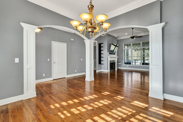 unfurnished dining area featuring hardwood / wood-style flooring, ceiling fan with notable chandelier, ornamental molding, and ornate columns