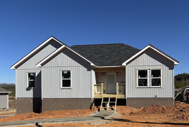 modern farmhouse with a porch and roof with shingles