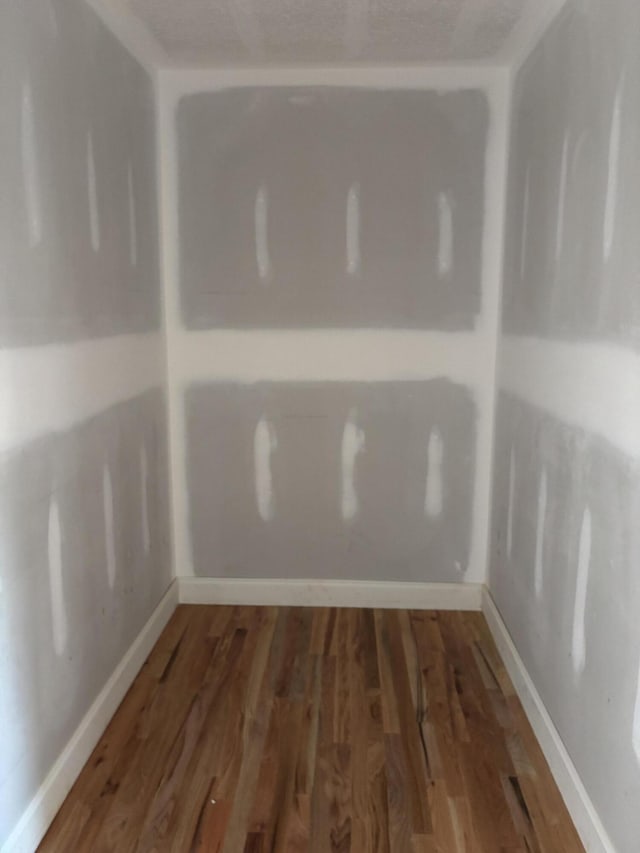 interior space featuring baseboards and wood finished floors