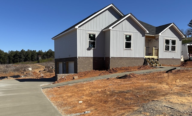 view of home's exterior with driveway, board and batten siding, and an attached garage