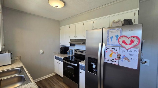 kitchen with crown molding, under cabinet range hood, light countertops, appliances with stainless steel finishes, and a sink