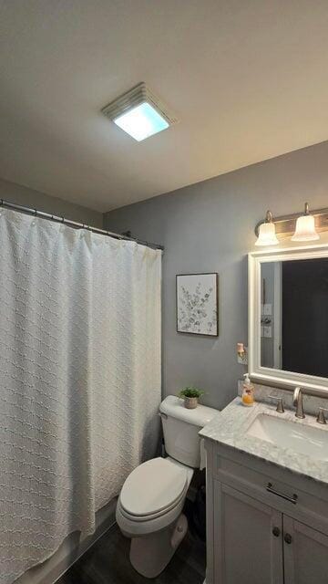 full bath featuring vanity, a shower with shower curtain, and toilet