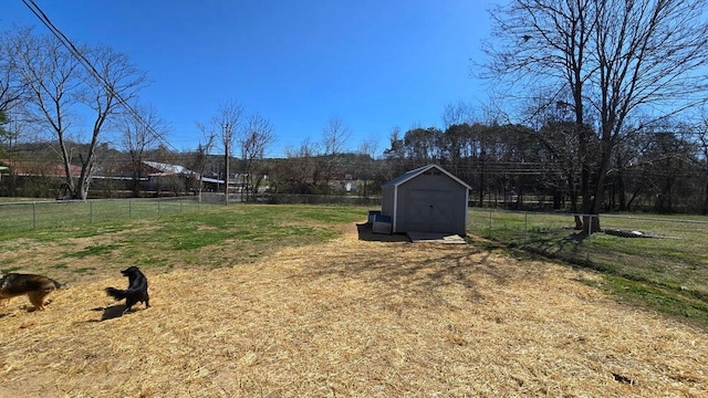 view of yard featuring an outbuilding, a shed, and fence