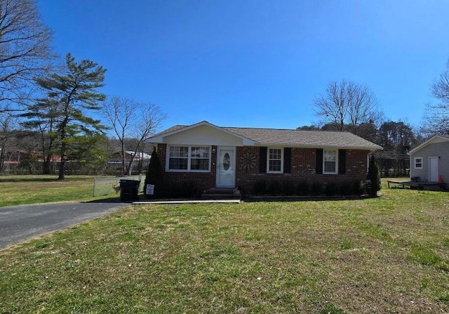 view of front of house with a front lawn, brick siding, and driveway