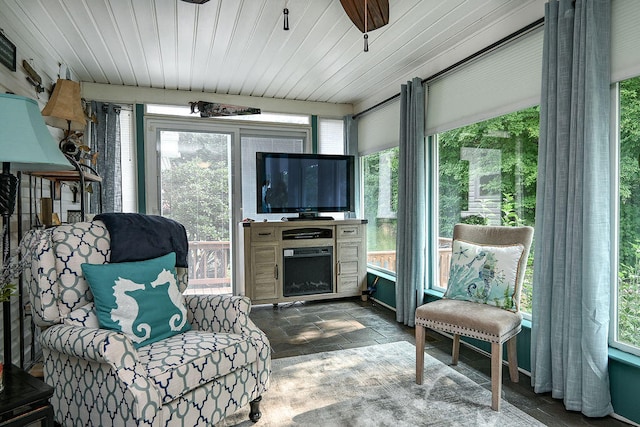 sunroom / solarium with a fireplace, a healthy amount of sunlight, and wood ceiling