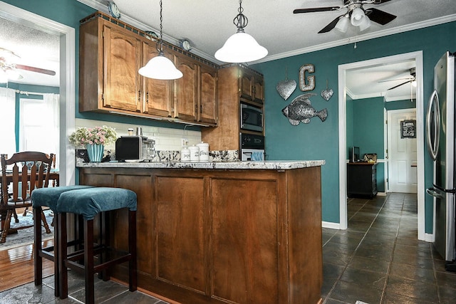 kitchen with hanging light fixtures, stainless steel appliances, kitchen peninsula, crown molding, and a textured ceiling